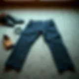 Stylish pair of pipe leg trousers laid flat with accessories