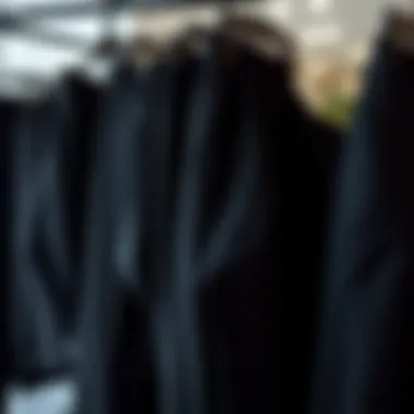 Different cuts of black trousers displayed on hangers